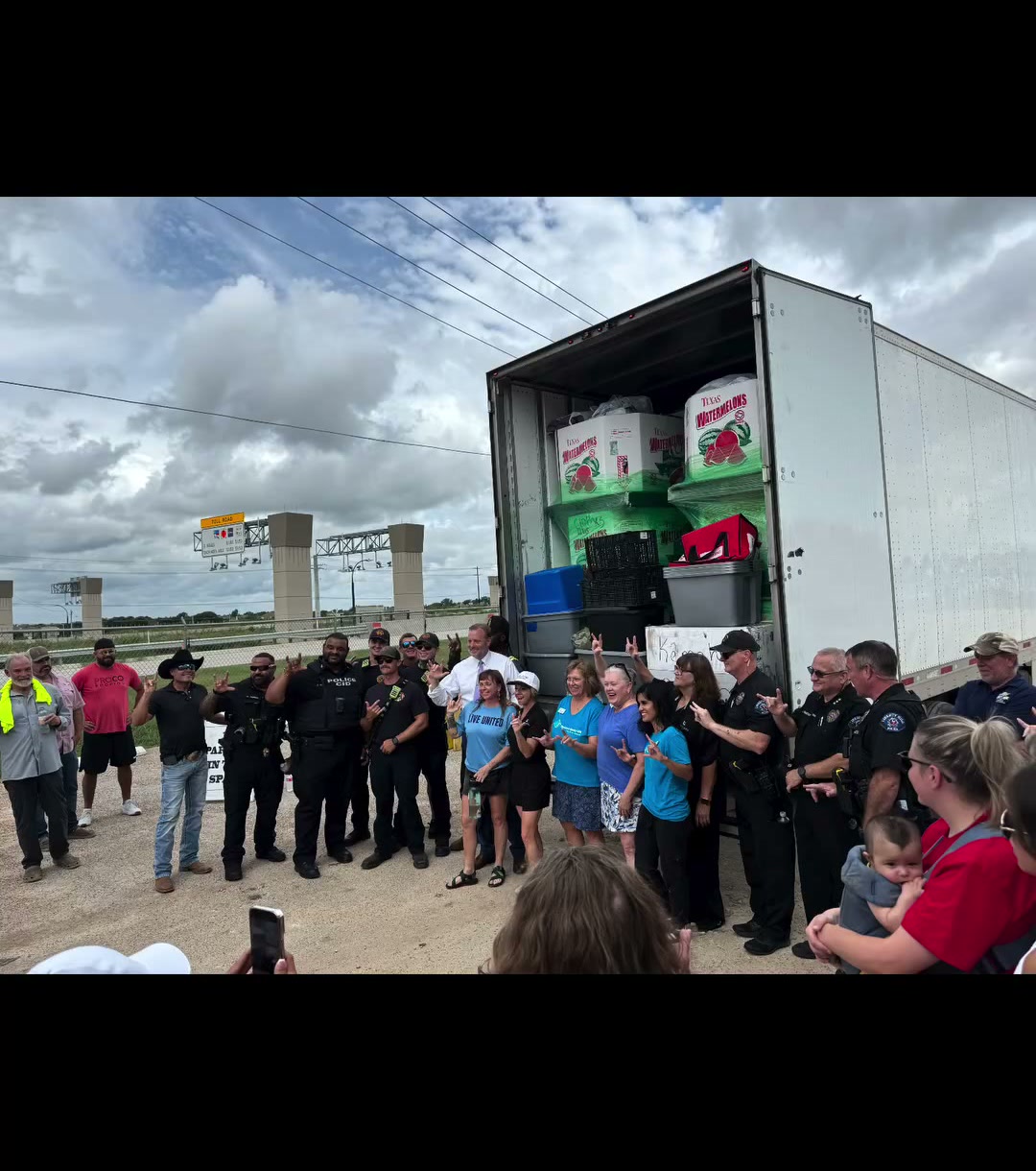 Local police, fire and neighbors gathered at the open truck of donated supplies for the Operation Liberty Hill relief drive