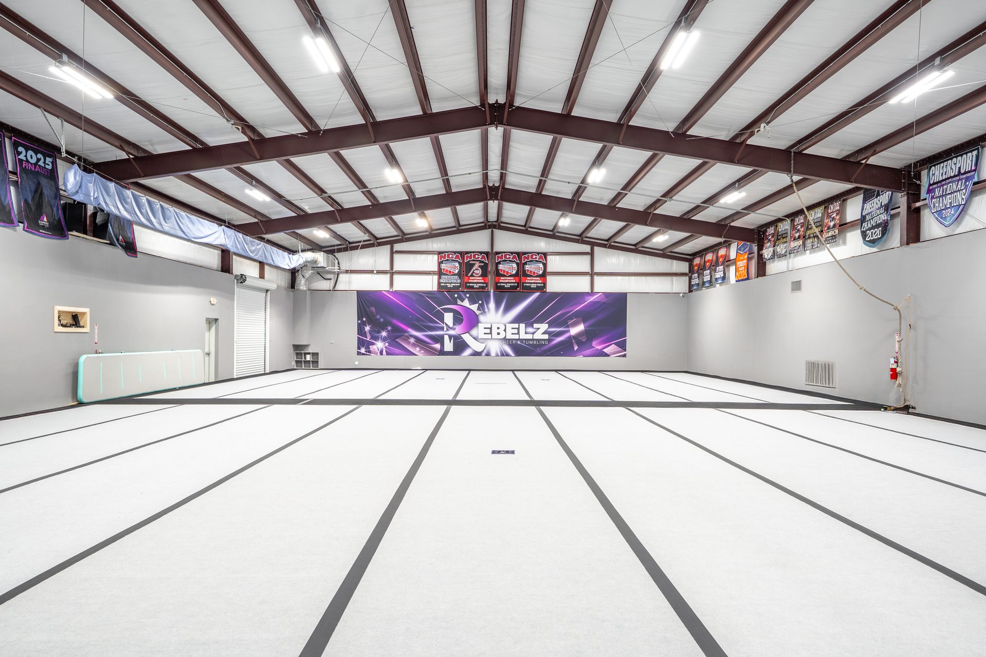 Rebelz Gym Rebelz Cheer and Tumbling banner wall with national championship banners