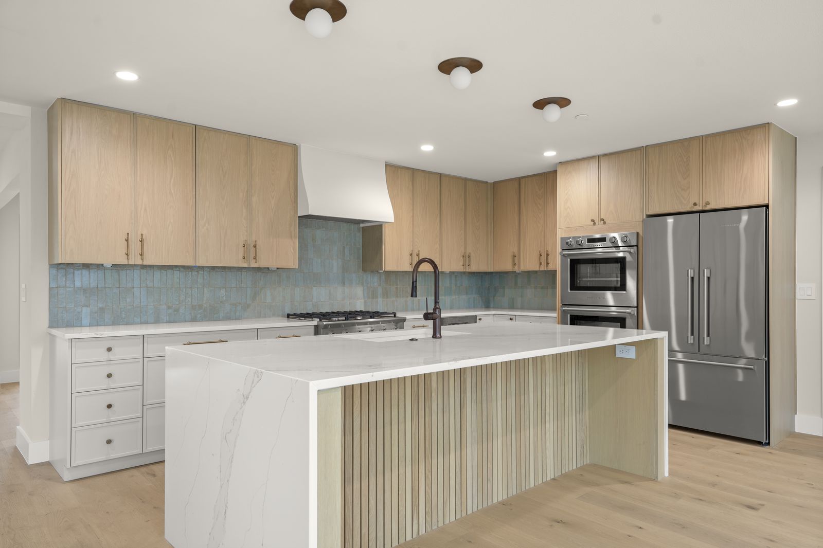Castle Ridge finished kitchen with white oak cabinets and marble waterfall island, Lost Creek, Austin, TX