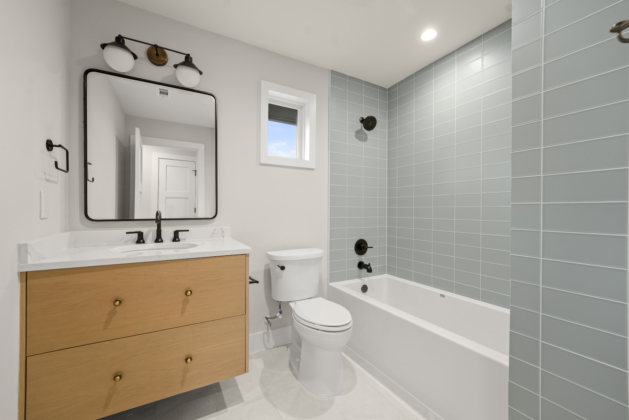 Castle Ridge finished bathroom with wood vanity and tiled tub, Lost Creek, Austin, TX