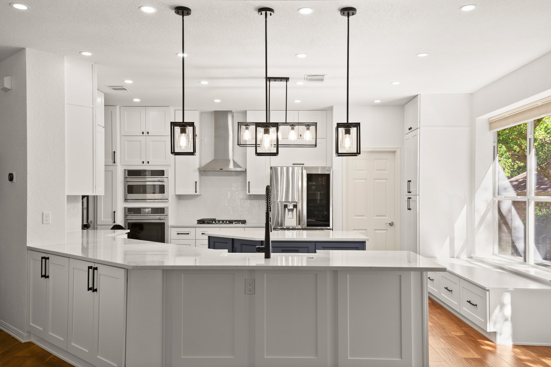 Oak Hill kitchen renovation, wide view with navy island and double wall ovens, SW Austin, TX