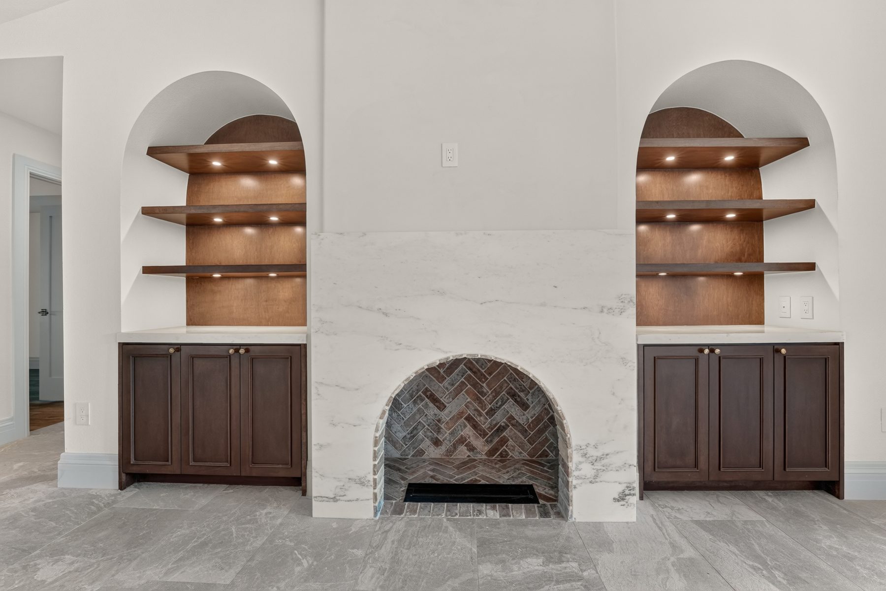 Living room fireplace with arched built-in shelving, North Austin, TX