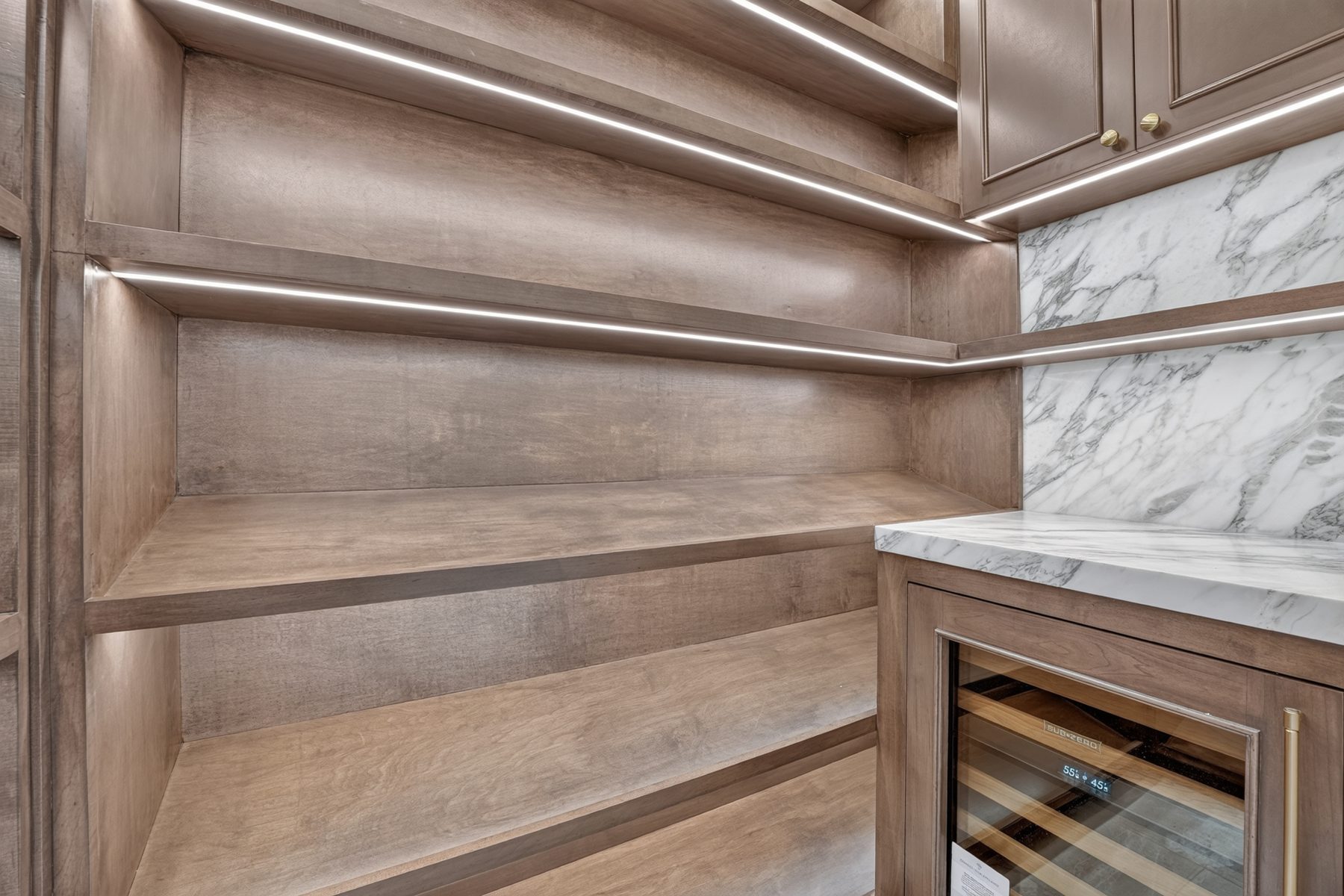 Lit wood shelving and wine fridge in the pantry, North Austin, TX